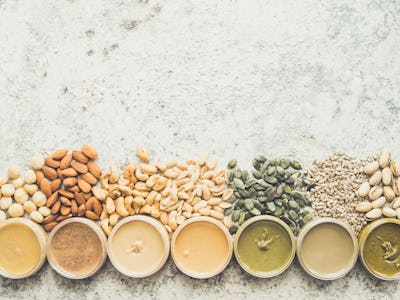 Nuts and seeds butter in jars with ingredients. Homemade raw organic peanut, almond, hazlenut, cashe...