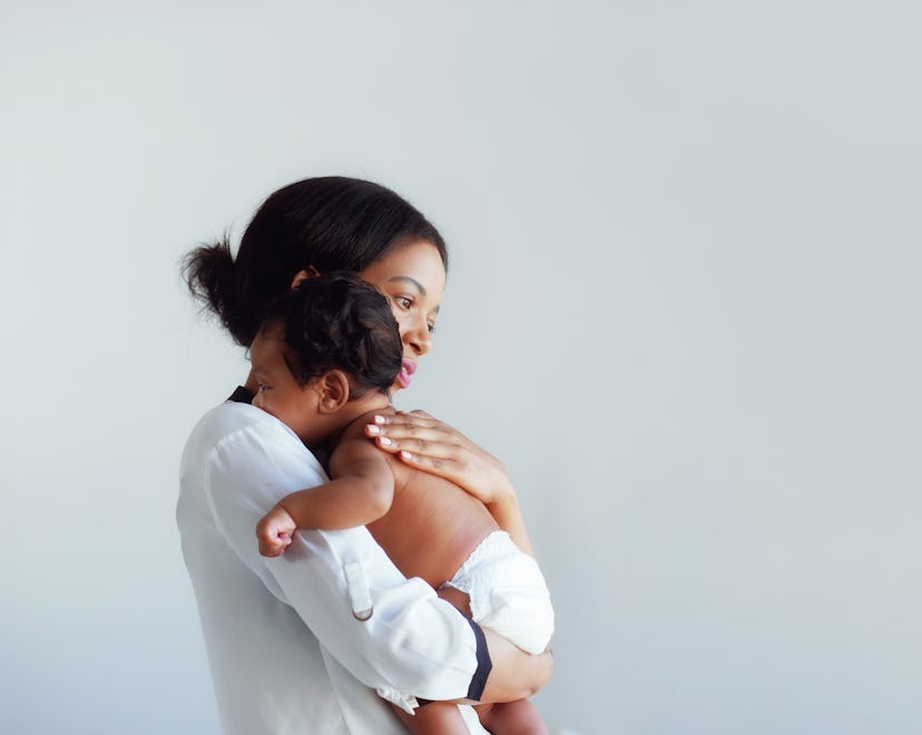 mom holding her newborn baby in a round up of Scorpio baby boy names