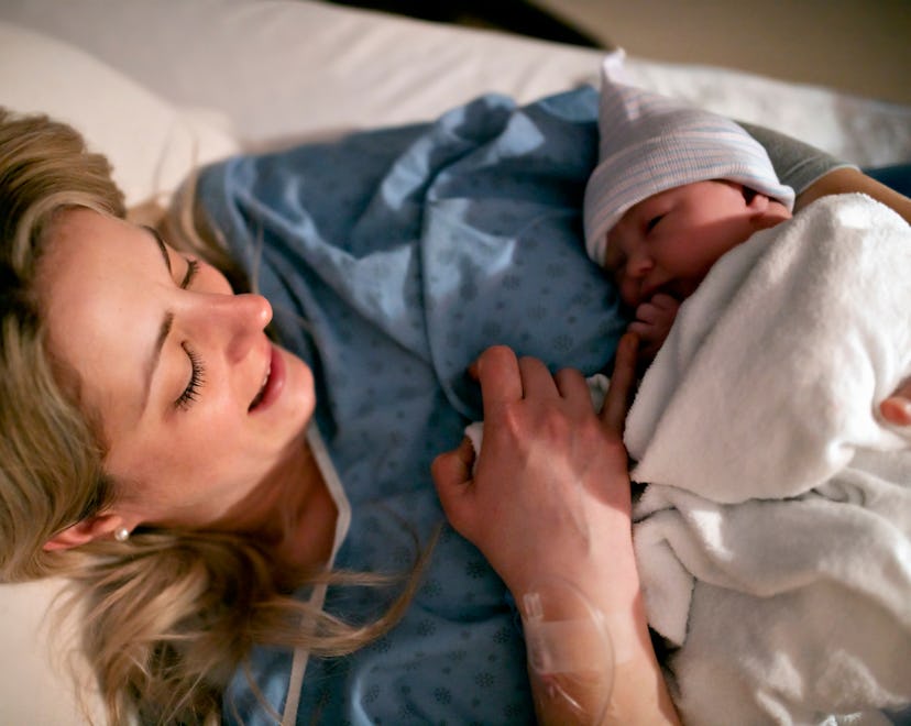 Woman holding baby post c-section, Doctors explain how to get out of bed after a c section.