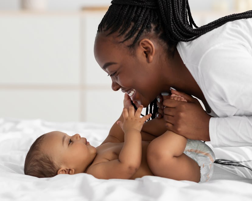 baby playing with mom on bed, sagittarius girl names