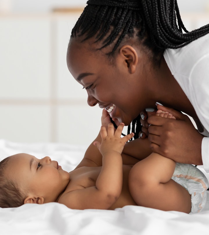 baby playing with mom on bed, sagittarius girl names