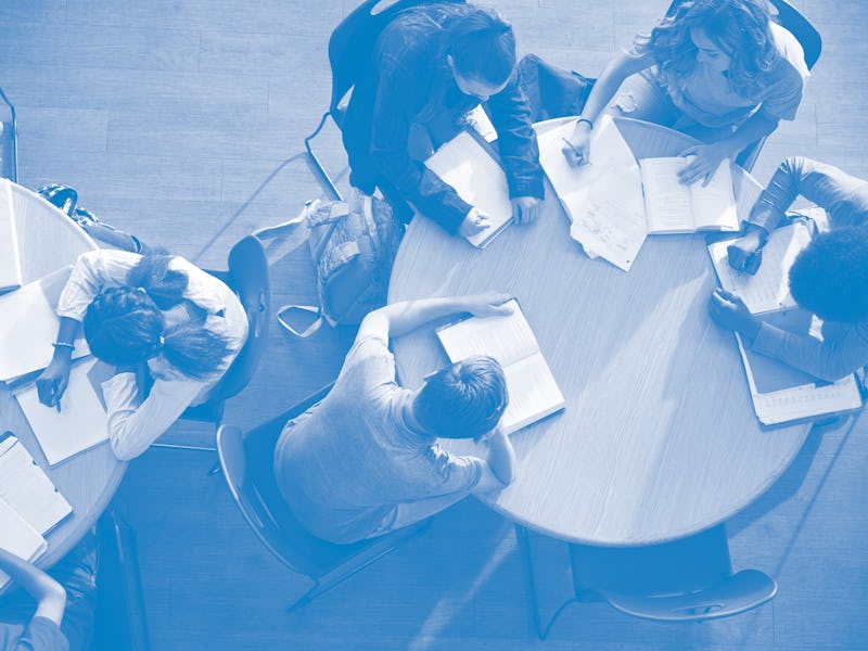 Overhead Shot Of High School Pupils In Group Study Around Tables