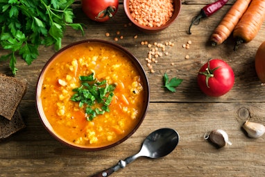 Red Lentil Soup with ingredients on wooden background, top view, copy space. Traditional turkish or ...