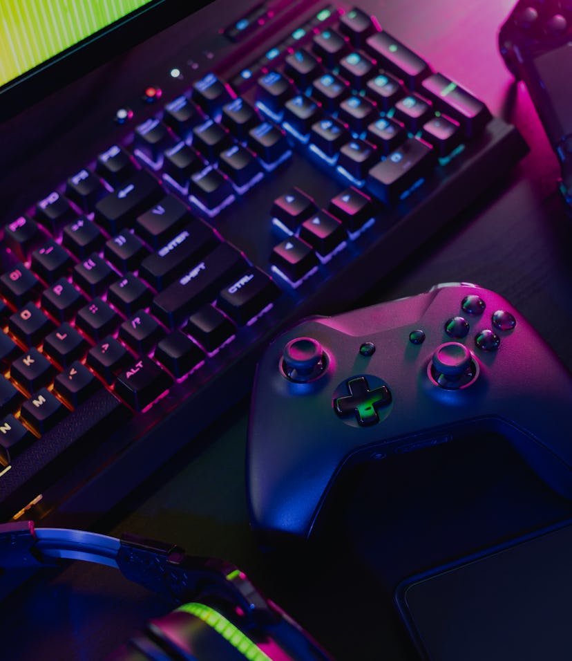 gamer work space concept, top view a gaming gear, mouse, keyboard, joystick, and headset with rgb co...