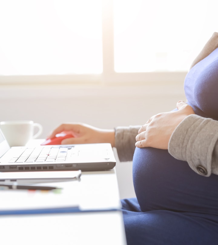 anonymous pregnant woman working on laptop computer