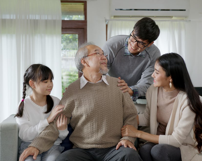 Asian elderly senior male grandpa sitting at sofa couch at home living room on quarantine in concept...