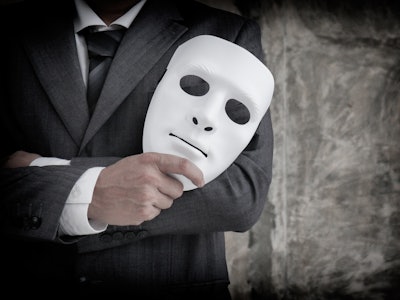 Businessman holding white mask in his hand dishonest cheating agreement.Faking and betray business p...
