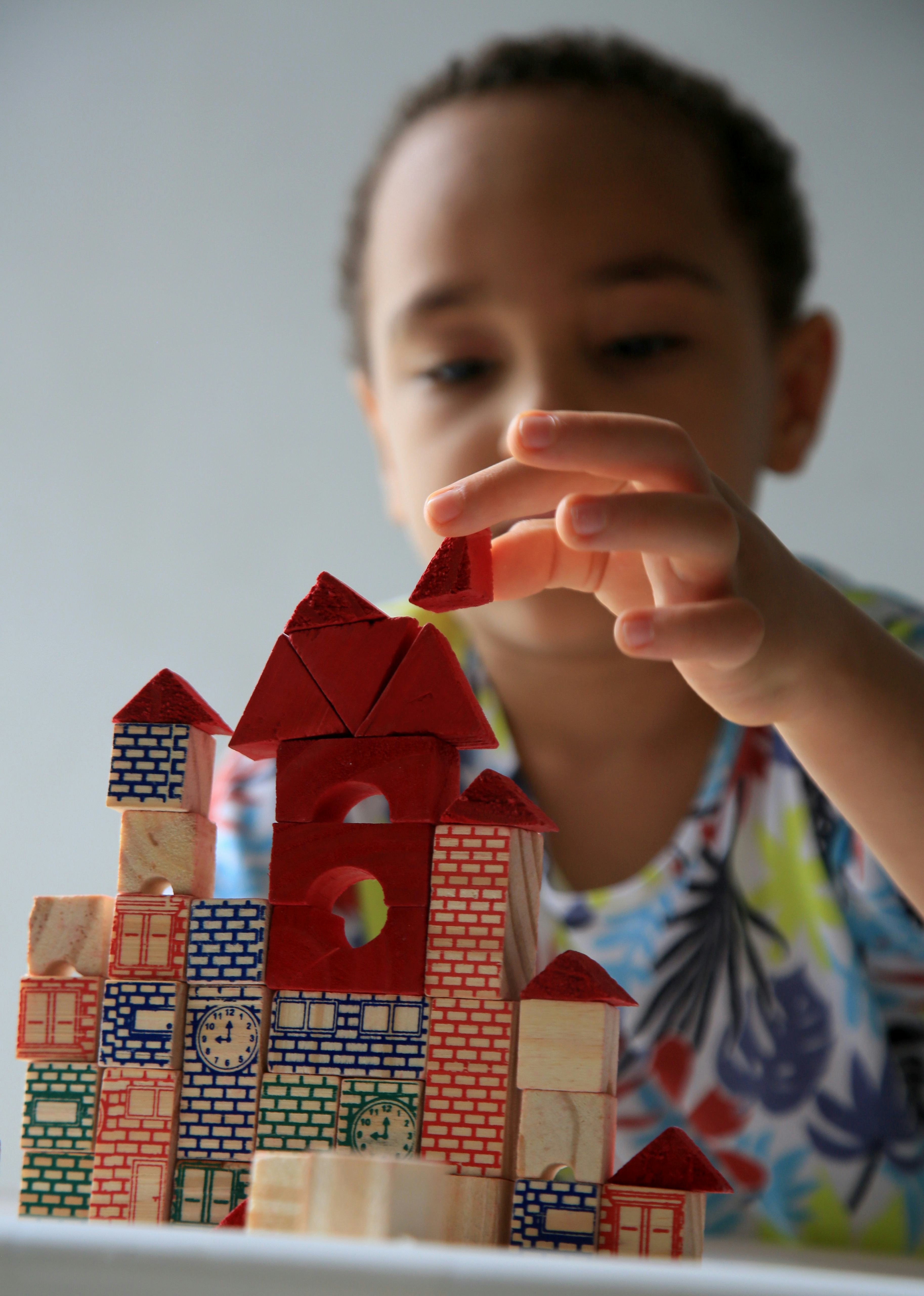 salvador, bahia, brazil - january 24, 2021: child playing with wooden block of children's constructi...