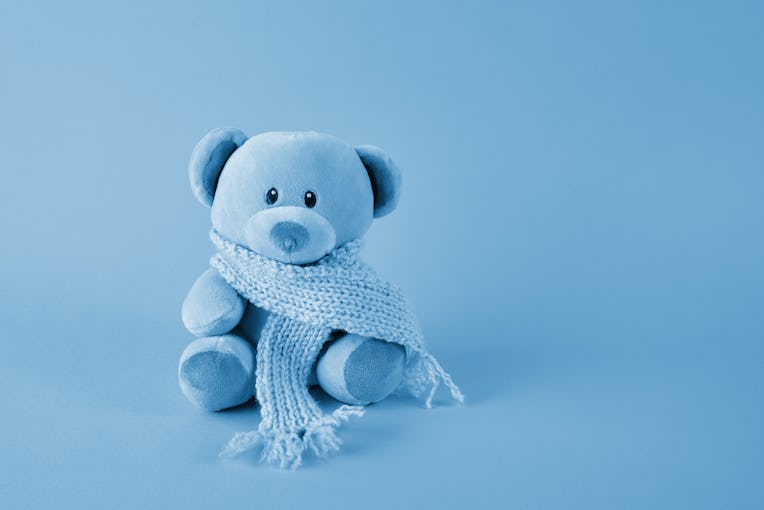 Blue teddy bear with scarf on blue background. Blue monday concept.