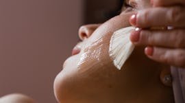 Close-up of a woman's face. The beautician makes a chemical peel. Skin care concept.