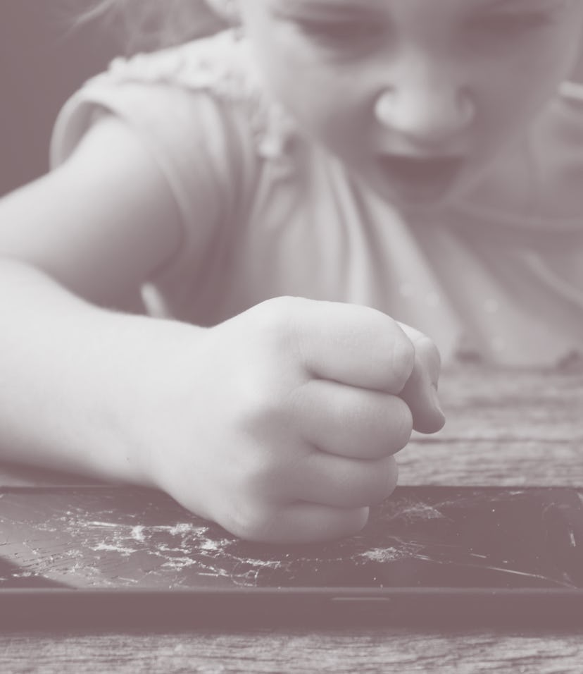 evil little girl blows her fists on a smartphone, breaks it