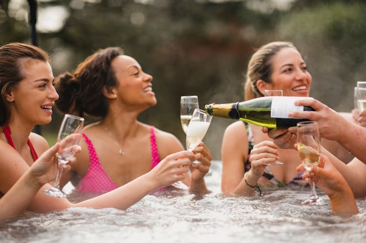 A group of friends enjoying champagne in a hot tub on a cold winter day, which would be a great mome...