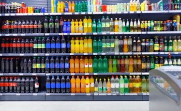 Blurred shelves with variety refreshing of beverage for sale in the supermarket.