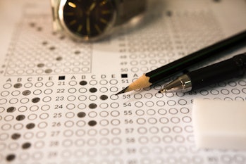 Pencil , pen and answer sheets or Standardized test form with answers bubbled. multiple choice answe...