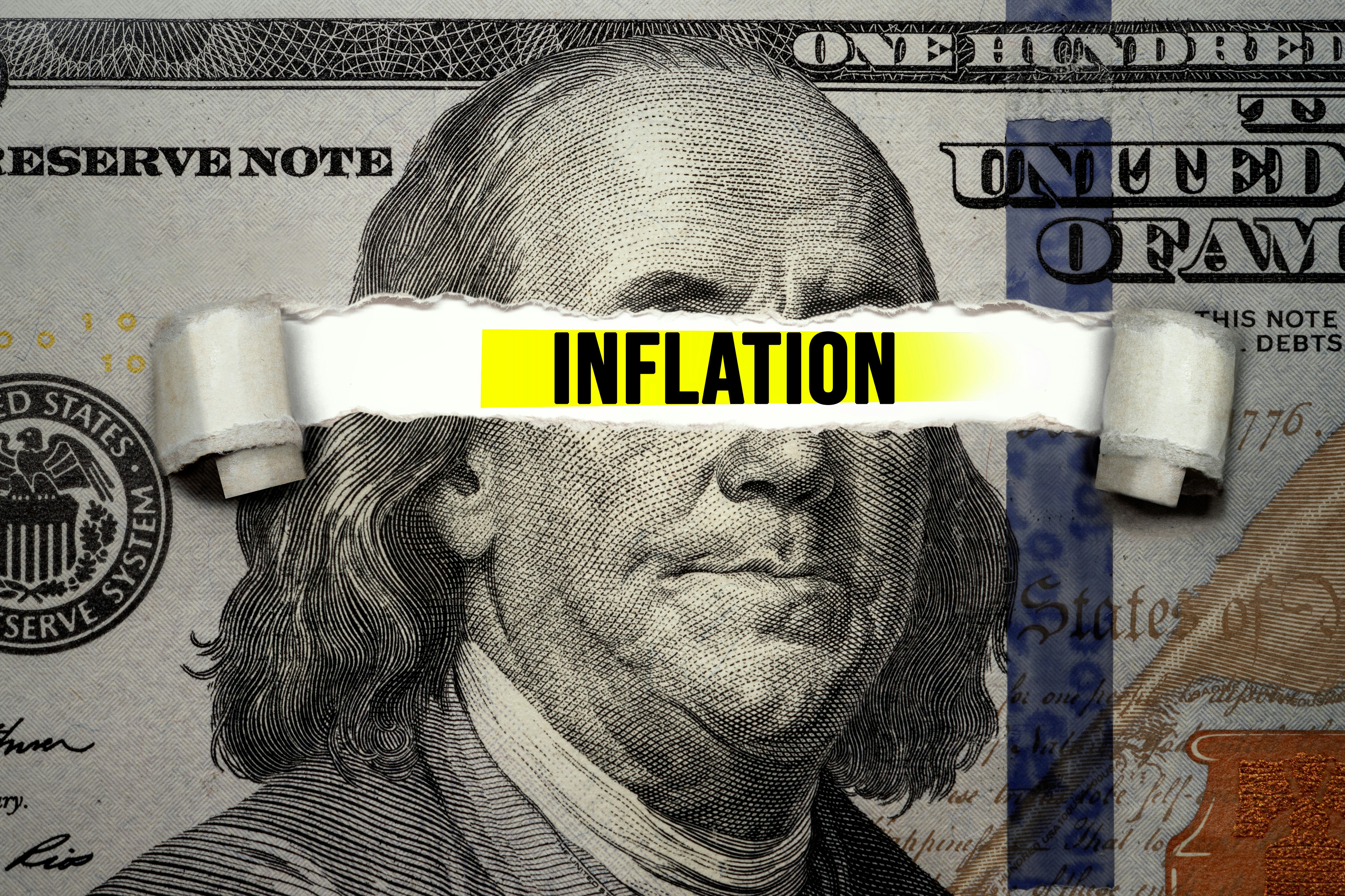 Torn bills revealing Inflation words. Idea for FED consider interest rate hike, world economics and ...