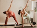 Two female friends trying some yoga poses for 2.