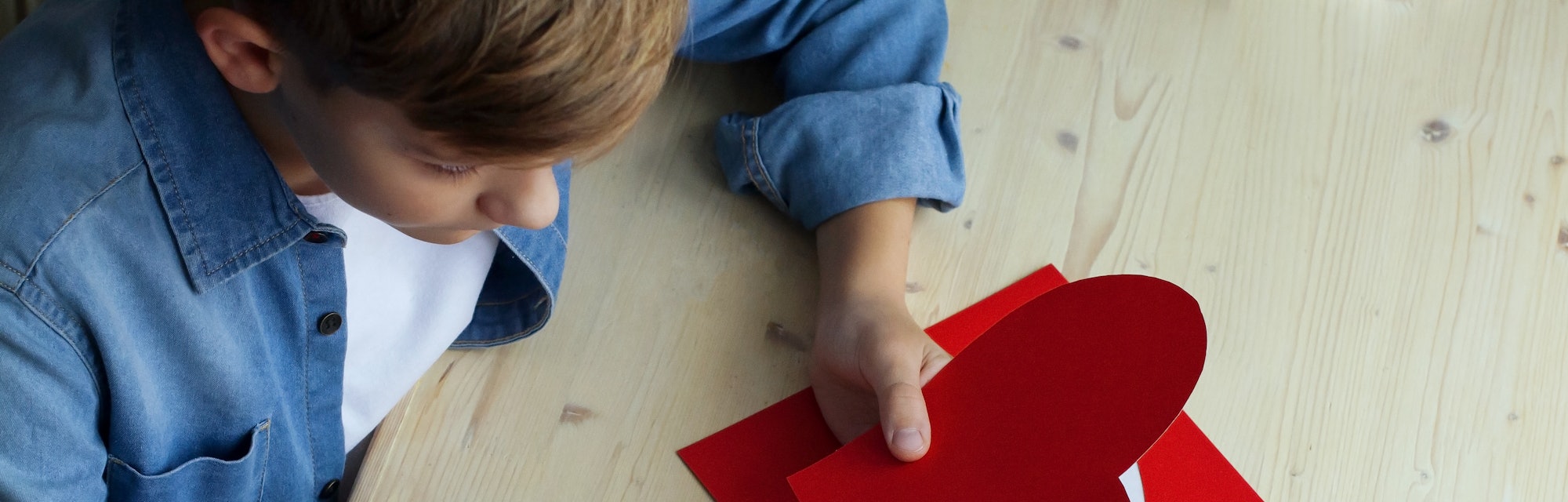 boy cutting out heart for Valentine's Day 