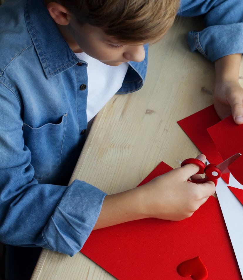 boy cutting out heart for Valentine's Day