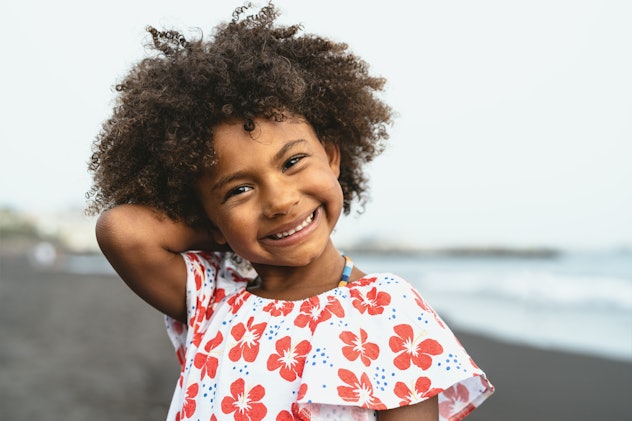 Portrait of Afro American child having fun on the beach. Qira is a girls name that starts with Q.