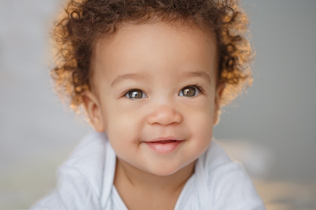 Cute Black baby boy smiling. Boy names that start with J include Jamie, a variation of James.