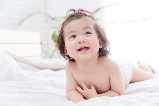 Baby girl smiling and looking up.