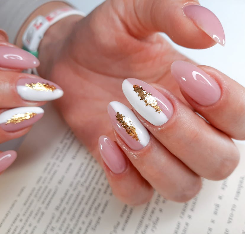 Abstract metallic nails featuring pink, gold, and white nail polish