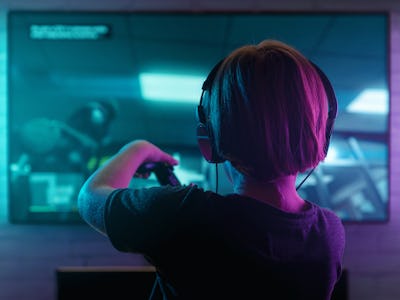 Little boy playing video game in the dark room