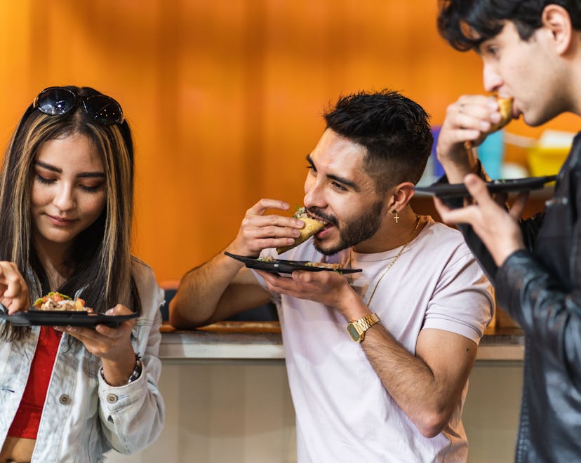 group of friends dining tacos at night in a street business