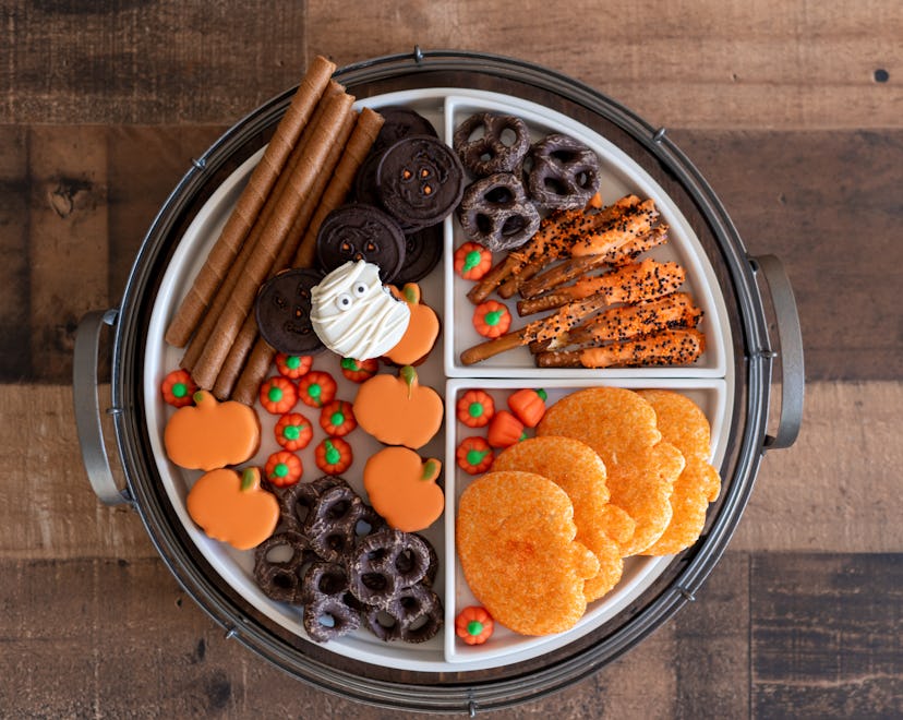 Halloween party charcuterie board with sweet treats, candy and cookies