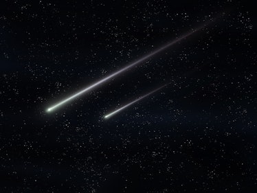 Two meteorites fly in the night sky. Bright meteors glow in the atmosphere. Beautiful shooting stars...
