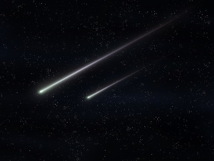Two meteorites fly in the night sky. Bright meteors glow in the atmosphere. Beautiful shooting stars...