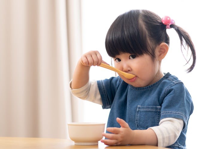 Asian girl eating in the living room