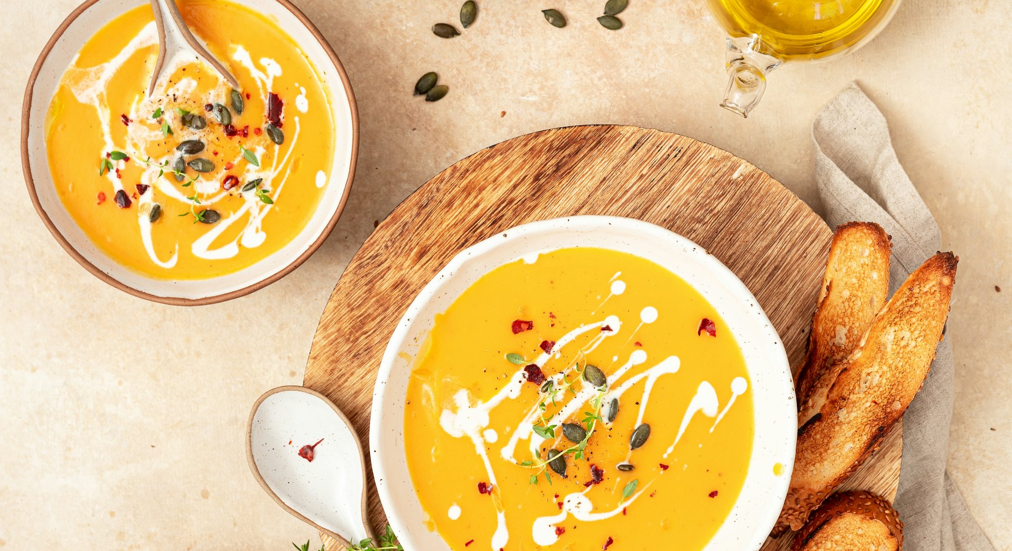 Vegetarian autumn pumpkin cream soup with spices, thyme and pumpkin seeds.