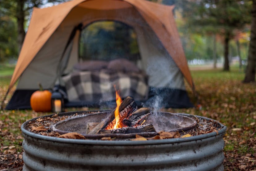 Campsite with a tent and metal fire pit, demonstrating that knowing what amenities are available is ...