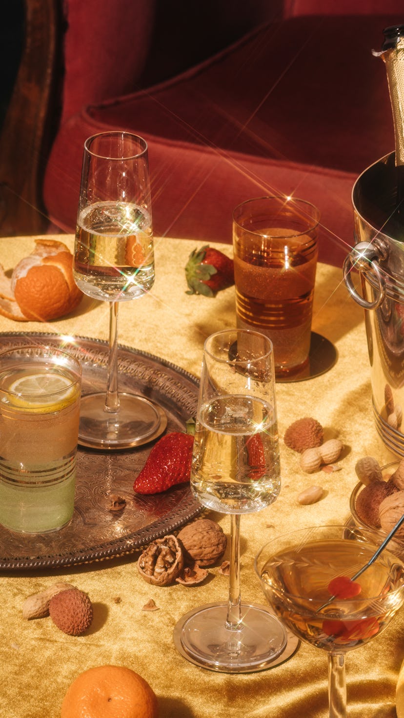 Valdobbiadene Prosecco flutes, a bottle, cocktails and fruit on a luxury colorful table. Prosecco is...