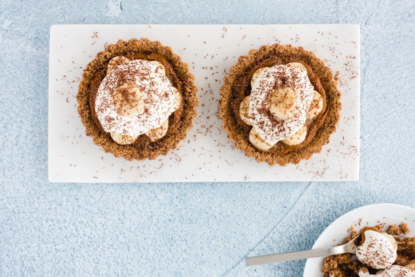 Closeup of homemade Banoffee Pie Tart with salted caramel, banana, whipping cream, decorated with gr...