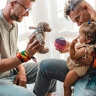 一对同性恋夫妇带着收养的女婴在家玩耍。万博体育app安卓版下载