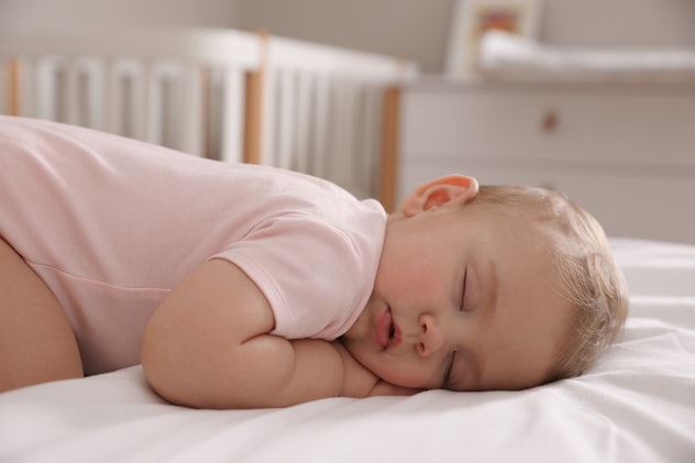 Adorable little baby sleeping on bed at home