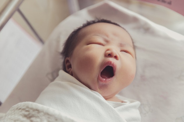 A portrait of sleepy cute newborn baby yawning in a list of girl names that start with L