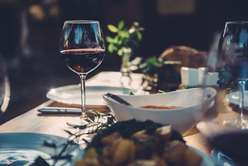 Glass of red wine at dining table in backyard patio