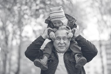 Shot of a happy senior man smiling looking away his grandson hugging him from behind copyspace relax...