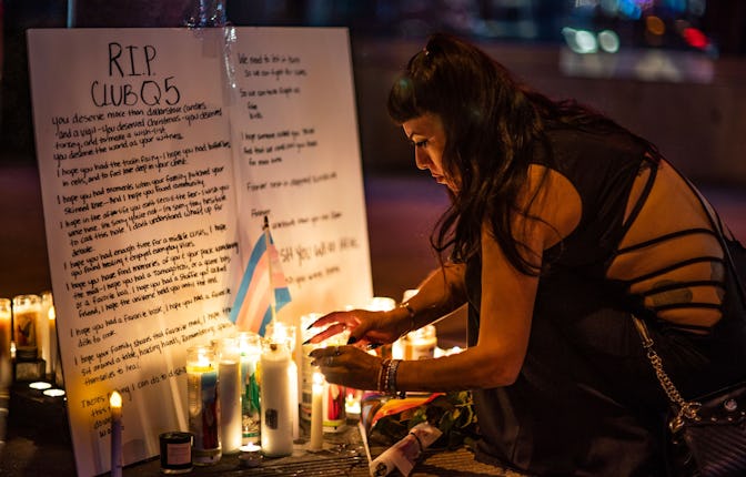 People light up candles at a makeshift memorial for the victims of Saturday's fatal shooting at Club...