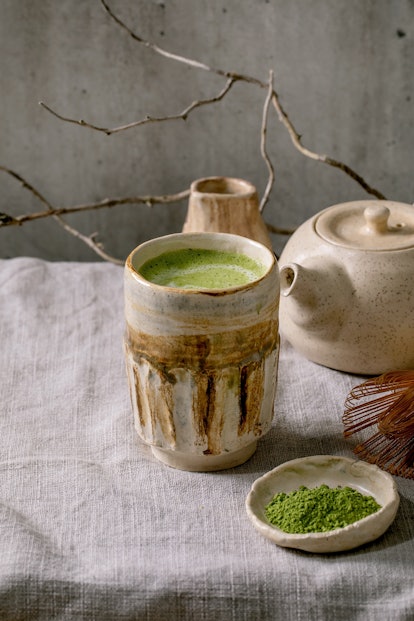 Traditional japanese hot green frothy tea matcha latte in handmade ceramic cup, powdered matcha, tea...