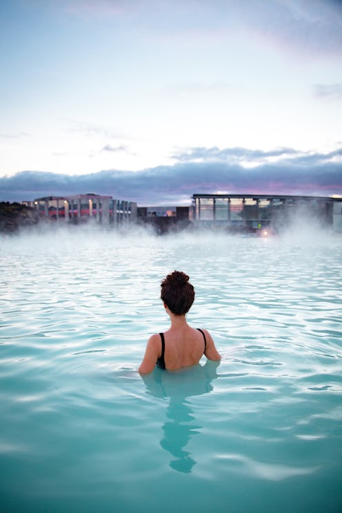Woman relaxes and enjoys of spa in hot spring Blue Lagoon in Iceland