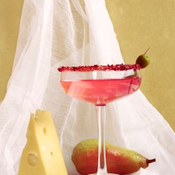 Rose wine cheese and pear still life. Front view against a background of white fabric.
