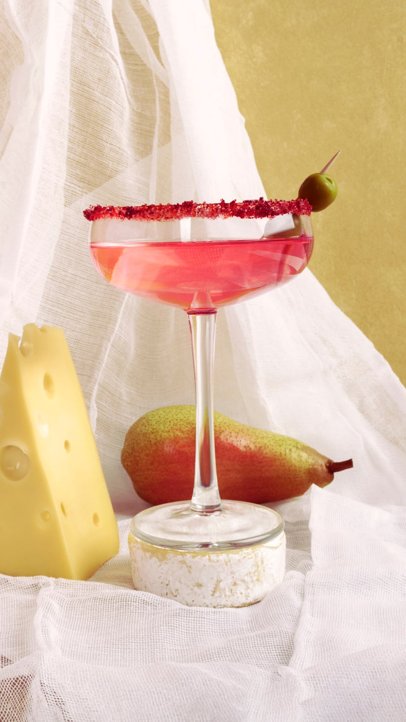 Rose wine cheese and pear still life. Front view against a background of white fabric.