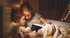 妈妈和女儿在睡觉前在床上看书