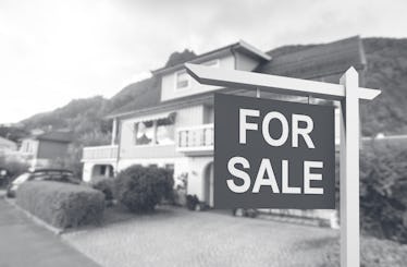 Beautiful urban house with 'for sale' sign.