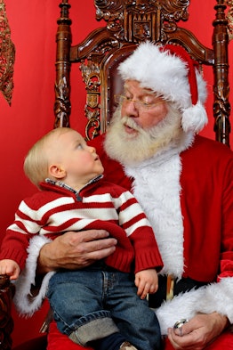 Baby boy sitting on Santa's lap at Christmas time needs the perfect Santa captions for Instagram.