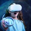 Child in VR glasses playing video games